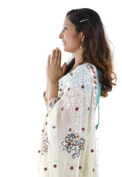 Side view of Mid Adult Indian woman in a greeting pose, isolated white background