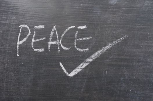 Peace - word written on a smudged blackboard with a tick