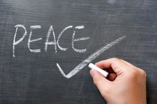 Peace - word written on a smudged blackboard with a tick