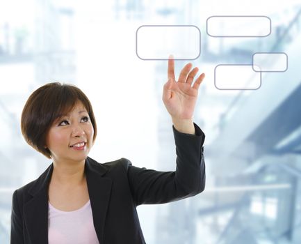 Mid adult Asian woman finger pressing on touchscreen monitor