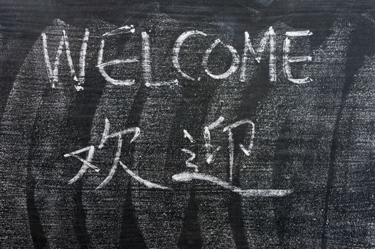 Welcome - word written on a blackboard with a Chinese translation