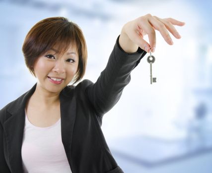 Mid adult Asian woman arms out holding a new key