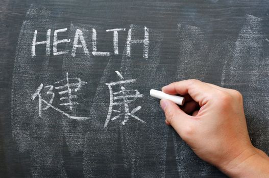 Health - word written on a blackboard with a Chinese version