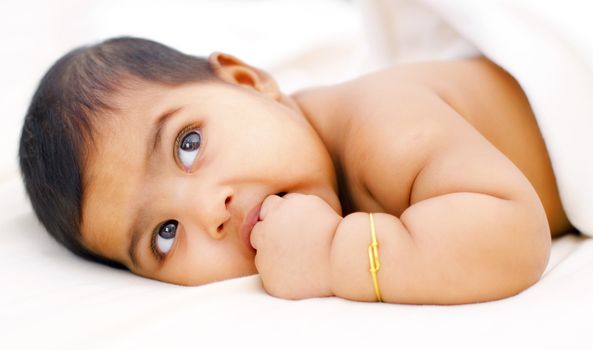 Six months old Indian baby girl sucking her fingers