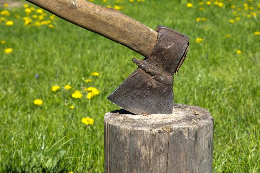 old rusty axe in a log