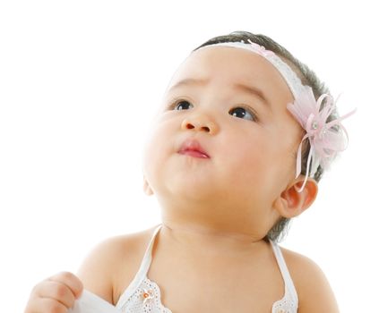 Curious asian baby girl looking up, isolated on white background