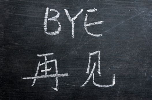 Bye- word written on a smudged blackboard with a Chinese translation
