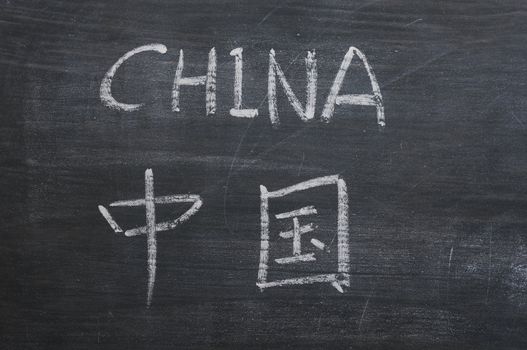 China - word written on a smudged blackboard with a Chinese version