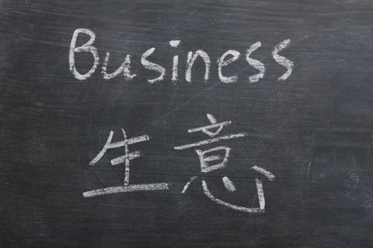 Business- word written on a smudged blackboard with a Chinese translation