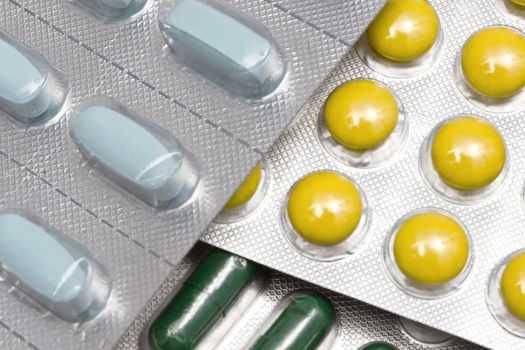 Colorful pills and capsules closeup on white background 
