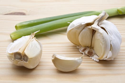 Garlic and green onion closeup on wood background