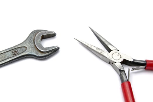 pliers and wrench closeup on white