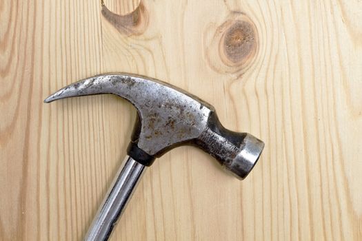 An old Hammer isolated on wood background 
