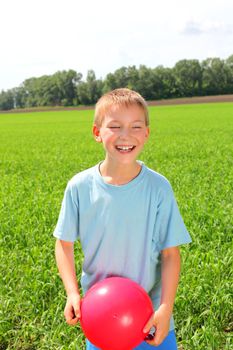 boy with a ball in the summer field