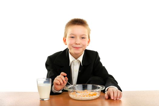 schoolboy eating corn flakes isolated on the white