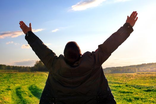 praying man silhouette on sunset background