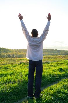 praying man silhouette on sunset background