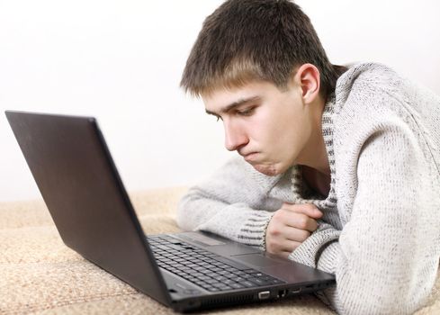 pensive young man with notebook on sofa