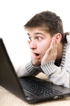 amazed young man with notebook on sofa