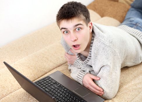 amazed young man with notebook on sofa