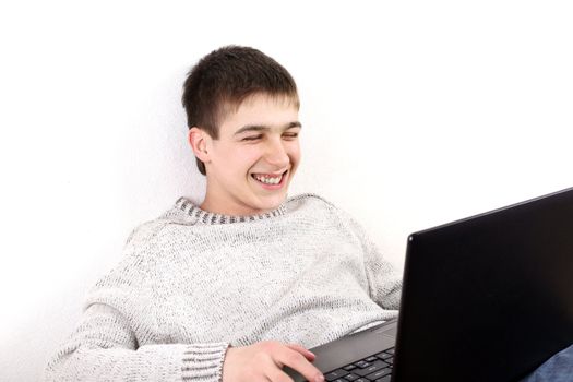 happy young man with notebook on sofa