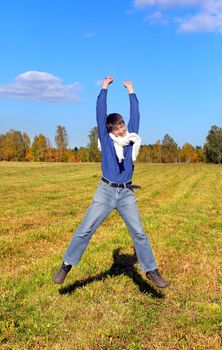 happy teenager jumping in the autumn field