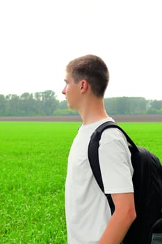 teenager with knapsack in the summer field