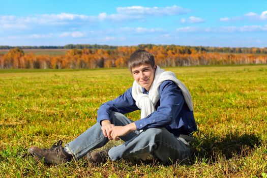 young man sitting in the autumn field