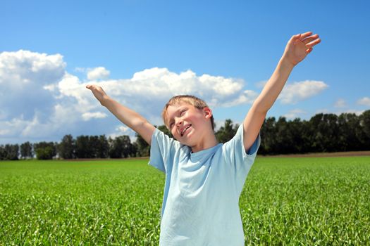 boy with hands up in the summer field