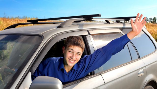 happy young man sit in the car and give salute gesture