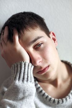 sad young man hide a face his hand closeup