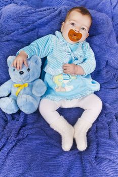 View of a newborn baby with a stuffed toy.