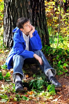 sad teenager is thinking in the autumn forest