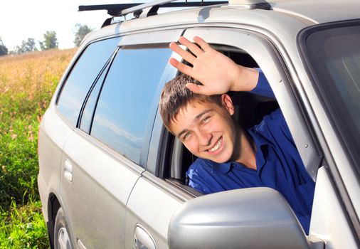 happy young man sit in the car and give salute gesture