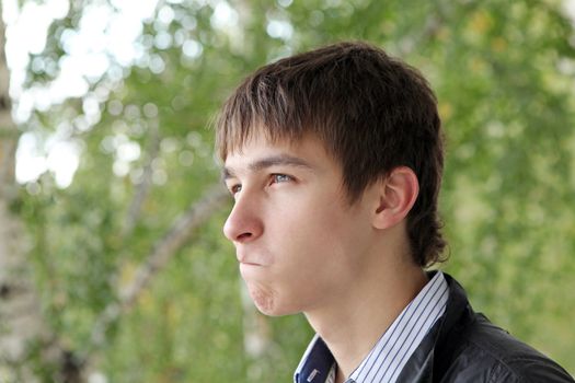 portrait of irresolute young man on the trees background