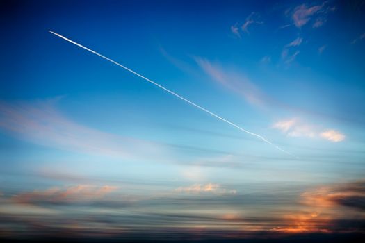 Track aircraft in the sky against the background of a beautiful sunset