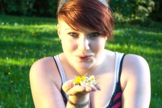 A beautiful young girl lying on the grass on a background of green