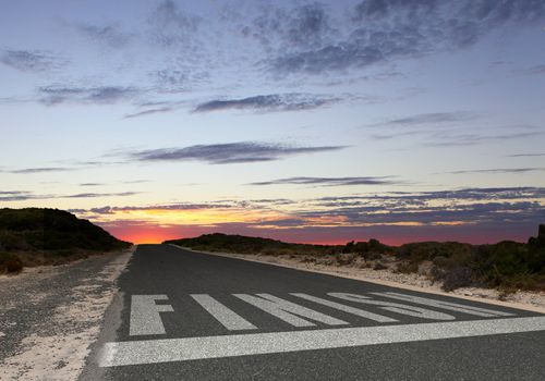 Image of a road with white arrow and finish sign