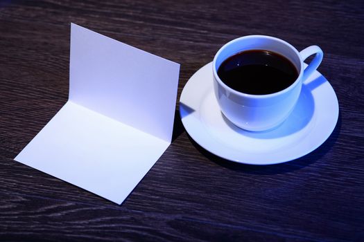 White cup with black coffee at business workplace