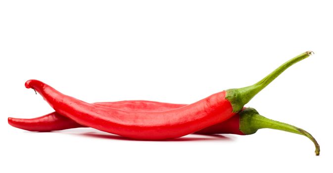 Closeup view of two red chili peppers isolated over white background