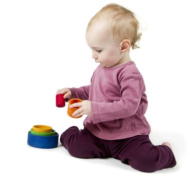 young child playing with colorful toy blocks in white background