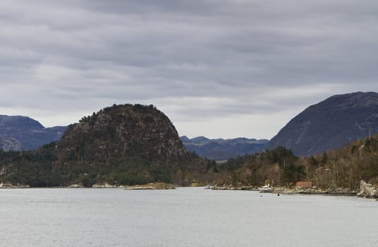 landscape in norway - coastline in fjord and dark sky