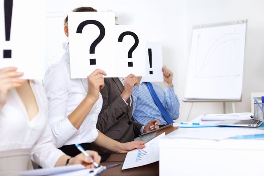 Image of businessmen in office with question marks