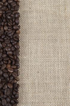 Background of burlap and coffee beans with a copy space.