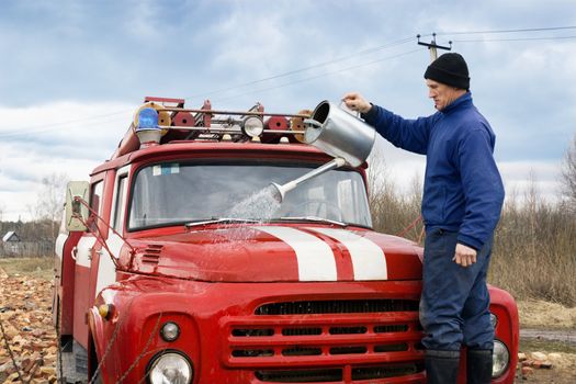 A man washes the old fire truck