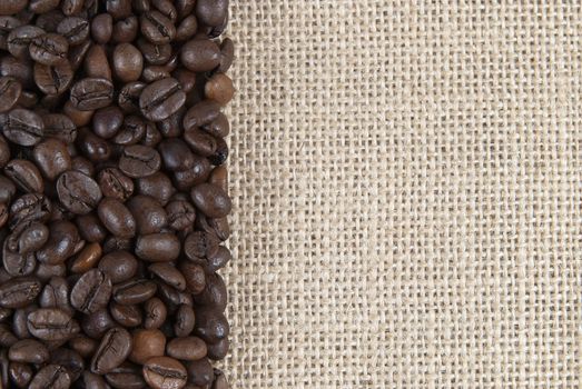 Background of burlap and coffee beans with a copy space.