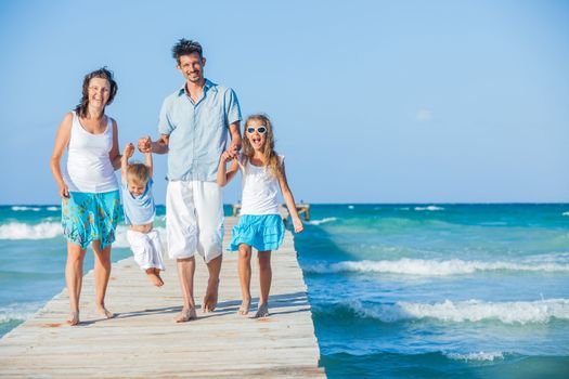 Family of four on wooden jetty by the ocean