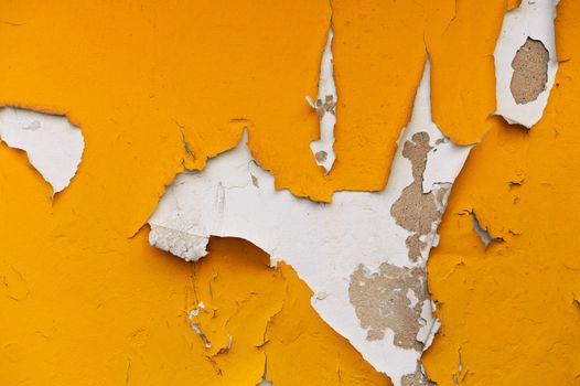 A wall with peeling plaster orange color. 