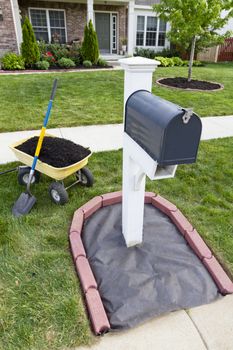 Laying mulch around the mailbox and placing edger bricks.