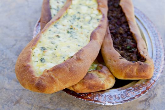Turkish Cheese and Ground Beef Pides complimented on ottoman style copper plate.